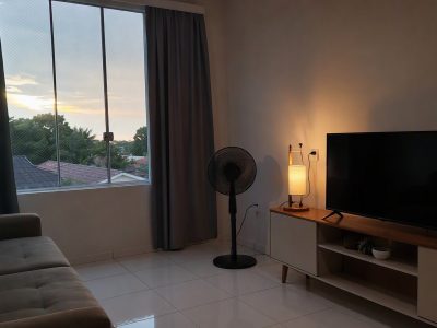 Sala com cortina blackout, tela mosquiteiro e ventilador para conforto térmico.