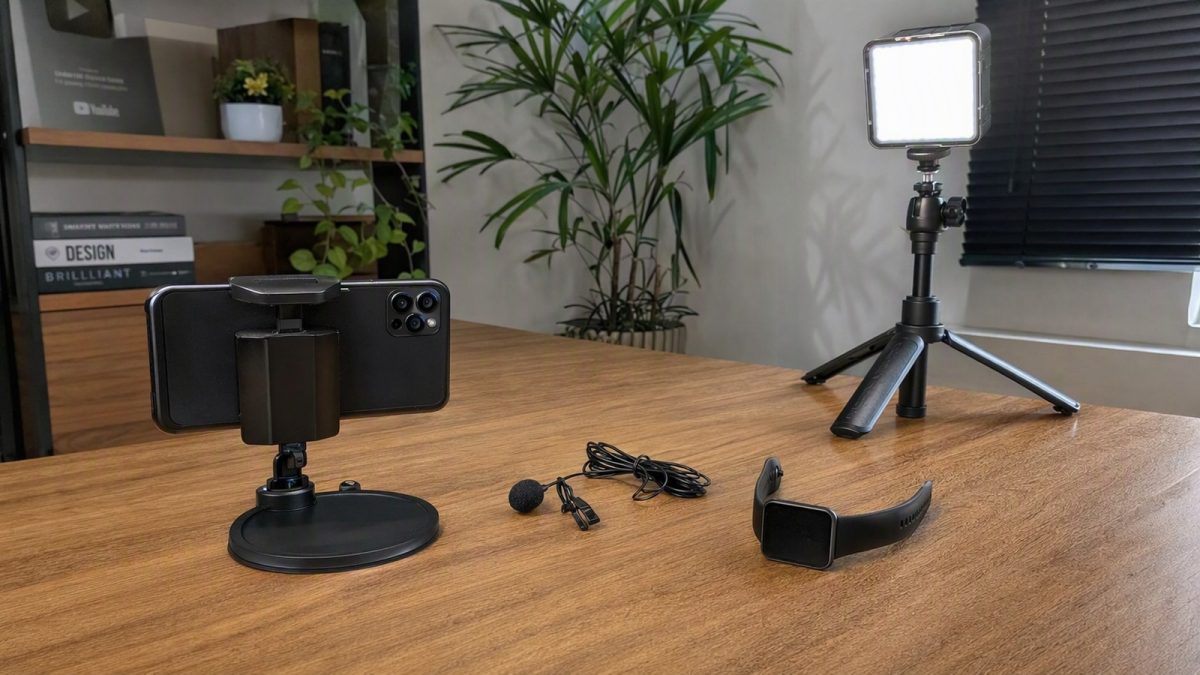 Setup simples para gravar vídeos com celular, microfone de lapela, luminária e smartwatch em mesa.