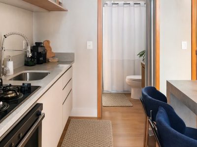 Tapetes de cozinha coordenados e cortina de box branca em ambientes integrados, com decoração neutra e organizada.