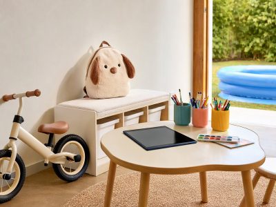 Cena com presentes para o Dia das Crianças: bicicleta de equilíbrio, mochila de pelúcia, tablet e potes de organização em sala; piscina inflável no quintal, sem pessoas.