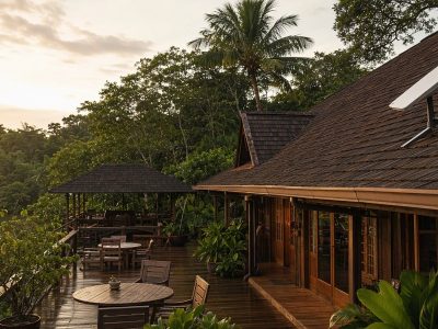 Pousada na Amazônia com antena de internet via satélite no telhado e deck externo cercado de floresta.